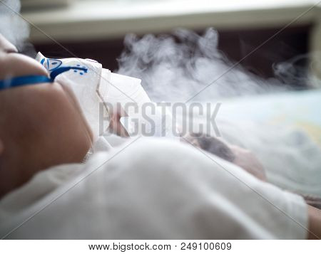 Asia Boy Sleeping On Bed While Making Inhalation With Nebulizer Mask At The Hospital