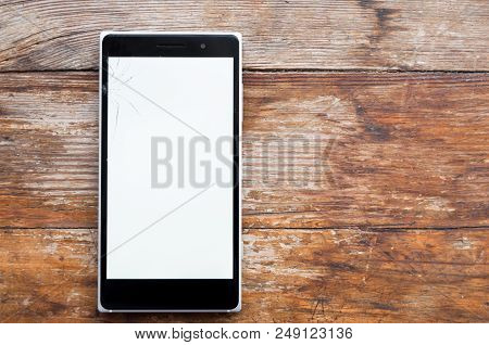 Smartphone With A White Broken Screen On A Wooden Background. White Screen