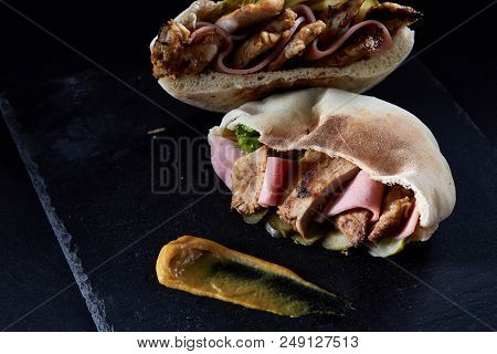 Stuffed Pita Bread With Pork, Ham, Piccoli And Sauce On Black Stony Background, Close-up, Selective 