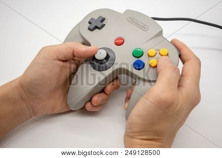 Nintendo64 : Bangkok, Thailand - July 12, 2018 : Hand Hodling The Grey Nintendo 64 Game Controller I