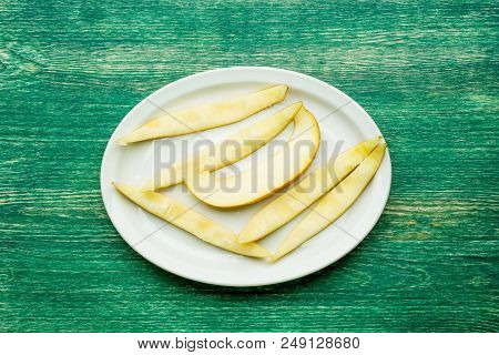 Yellow Sliced Melon Fruit On Plate. Top View .