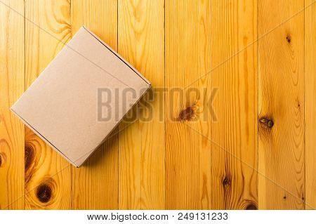 Craft Unlabeled Cardboard Box With Copyspace For Text On Wooden Background