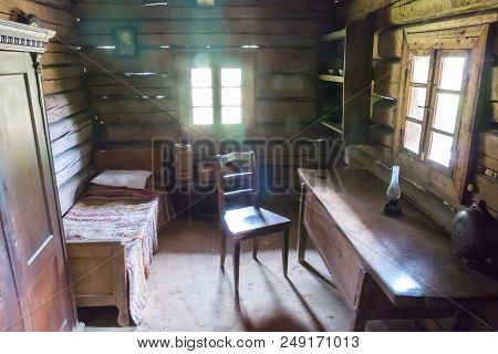 A Tiny Room In A Wooden Hut. The Room Has A Wooden Table, A Chair And Everything Else. Sunshine Thro