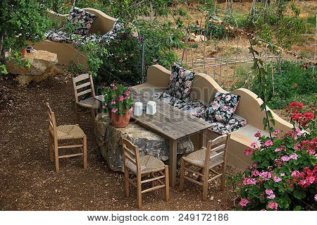 Rustic Seatings In A Garden During Summer.