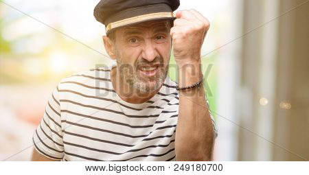 Sailor captain man smoking a tobacco pipe irritated and angry expressing negative emotion, annoyed with someone