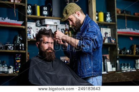 Hipster Client Getting Haircut. Barber With Hair Clipper Works On Hairstyle For Bearded Man Barbersh