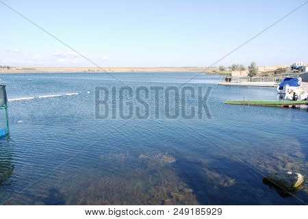 Transparent Clear Water Of A Blue Lake With Piers Along The Shore