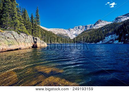 Lake Verna with rocks and mountains around at autumn. Rocky Mountain National Park in Colorado, USA. 