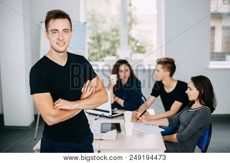 I Am The Part Of Cohesive Team. Young Successful Man Specialist Portrait With Colleagues Meeting Beh