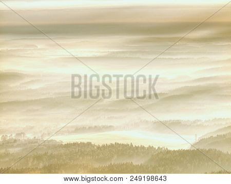 The Misty Land. High Trees And Hill Peaks Increased From Thick Fog. The First Sun Rays Create Sharp 