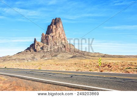 Agathla peak with the road to Monument Valley  in the foreground, Arizona, United States.