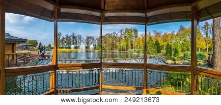 Luxurious View From The Gazebo To Relax On A Pond With Fountains And Resting People Nursing Small Du