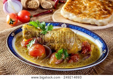 Chicken Curry And Roti On Wooden Table