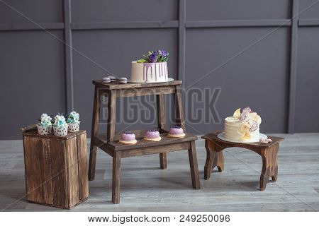 Cakes And Macaroons On Wooden Chair On A Dark Background