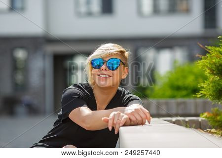 The Girl Plus Size In Sunglasses Smiles, Joyful, Happy On A Bright Sunny Day In The Street, A Haircu