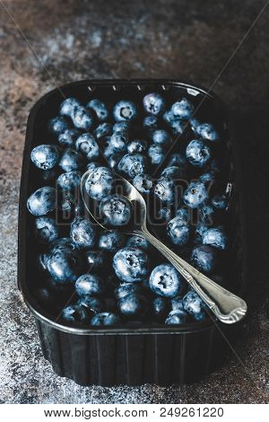 Freshly Picked Blueberries In Container On Dark Background. Selective Focus, Toned Image