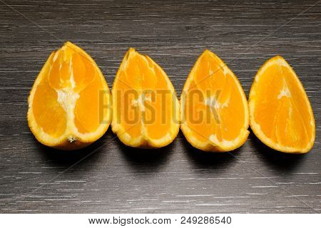 Orange Fruit. Four Orange Slice And Pieces Isolate On Black Wood.