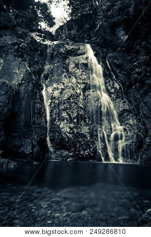 Long Time Exposure Of Waterfall At River In Dark Colors