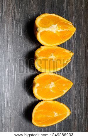 Orange Fruit. Four Orange Slice And Pieces Isolate On Black Wood.
