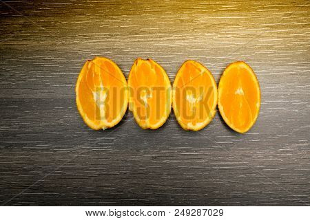 Orange Fruit. Four Orange Slice And Pieces Isolate On Black Wood.