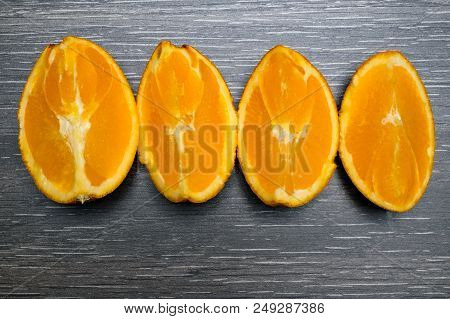 Orange Fruit. Four Orange Slice And Pieces Isolate On Black Wood.