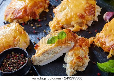 Pork Chops Topped With Finely Chopped Onions, Mayo And Melted Cheese On A Black Slate Plate On A Woo
