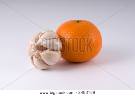 Knoblauch und reif Orange auf hellem Hintergrund