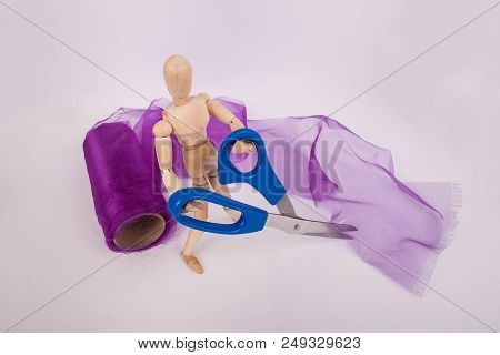 Jointed Doll Holding Scissors Cutting Purple Tulle Fabric On White Background