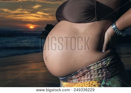 Close Up Of A Cute Pregnant Belly With Sunset Background
