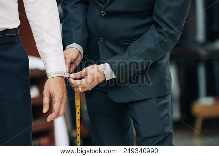 Cropped Image Of Tailor Measuring Cuff Of Male Client