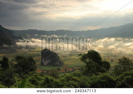 Rock Mountain Protruding From Rice Field. Morning Fog On Sunrise In The Phulanka, Phayao Thailand.