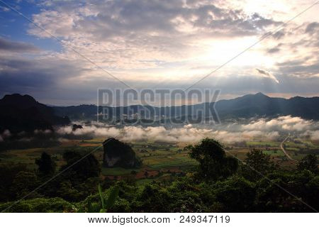 Rock Mountain Protruding From Rice Field. Morning Fog On Sunrise In The Phulanka, Phayao Thailand.
