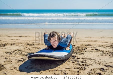 Young Man Surfer Training Before Go To Lineup On A Sand Beach. Learning To Surf. Vacation Concept. S