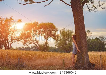 Cute Smiley Girl Embracing The Oak Tree In Nature.