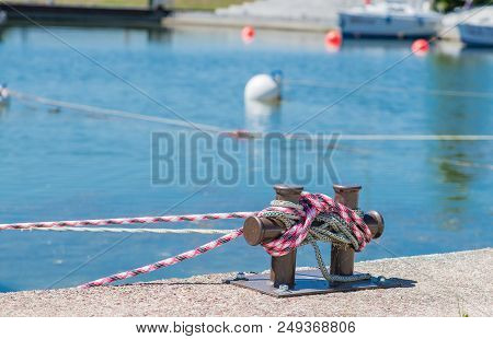 Marina Bollard Bitt At Jetty For Boats, Ships And Yachts Mooring. Lose Up Of Rope Tied Up On A Bitt.