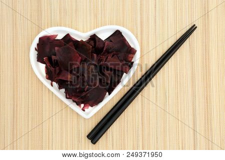Dulse seaweed super food in a heart shaped dish with chopsticks on bamboo background. Very high in minerals and protein.