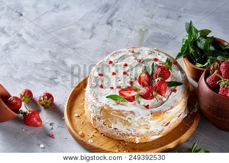 Strawberry Tart Covered With Whipped Sour Cream Surrounded By Organic Ingredients Over White Backgro