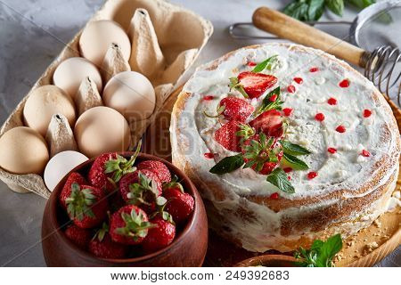 Strawberry Tart Covered With Whipped Sour Cream Surrounded By Organic Ingredients Over White Backgro
