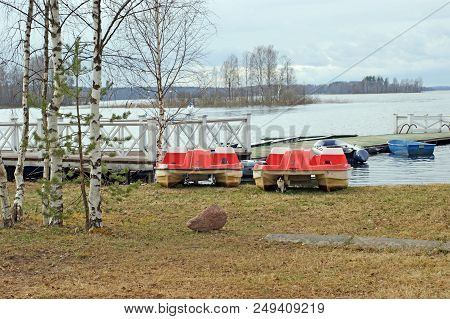 Pier, Pontoon On The Waterside Of The Lake Seliger With Catamarans And Boats With Forest On The Back