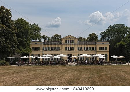 Guests On The Terrace In Front Of The Restaurant In The Historic Park Schoenbusch, Aschaffenburg, Ge