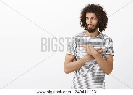 Studio Shot Of Handsome Adult Bearded Man With Afro Hairstyle, Pointing And Looking Right With Disda