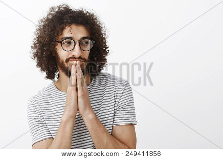 Wasit-up Shot Of Handsome Flirty Bearded Male With Curly Hair, Looking Aside And Smirking, Wearing G