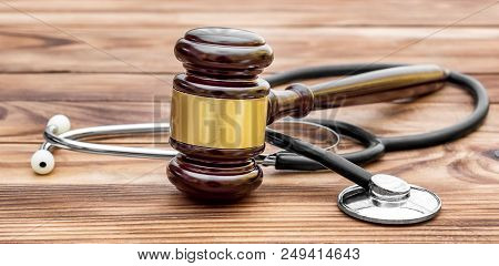 Gavel With Stethoscope On Wooden Table. Medical Law.