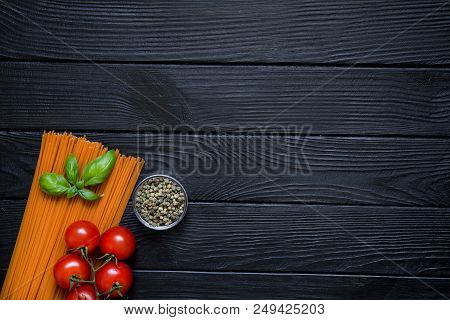 Organic Spaghetti With Fresh Cherries, Green Pepper In Little Glass Bowl And Basil Leaf On Black Woo