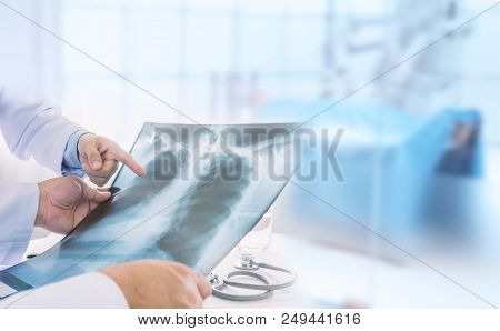 Doctor Examining At Lungs Radiograph X-ray Film Of Patient In Operation Room.