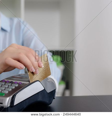 Administrator At Gym Using Payment Terminal For Paying By Credit Card