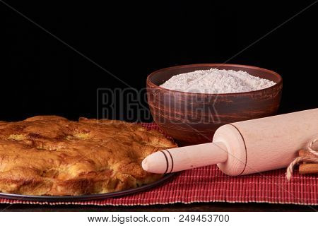 Apricot Pie And A Bowl With Flour And Other Ingredients On Wooden Table