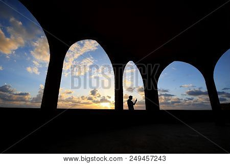 Silhouette Of A Man Tking A Selfie Among Arches During Sunset In Batroun, Lebanon.