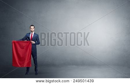 Businessman standing with red toreador cloth in his hand in an empty room