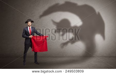 Businessman standing with red cloth in his hand and imp shadow on the background